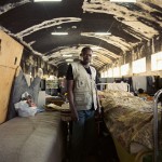 Italy, Palermo, Sicily. Daouda (27), a Malian, stands next to his bed at the immigration reception centre. He arrived in Italy nine months ago and has since found a job for the summer season in a restaurant. Thousands of would-be asylum seekers have made the perilous crossing from North Africa to the southern stretch of Sicilian coastline.