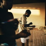 Fishermen repair their nets in a warehouse near Porto Bandim.