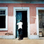 A man crying at the entrance door of his house after finding out that his friend has died.